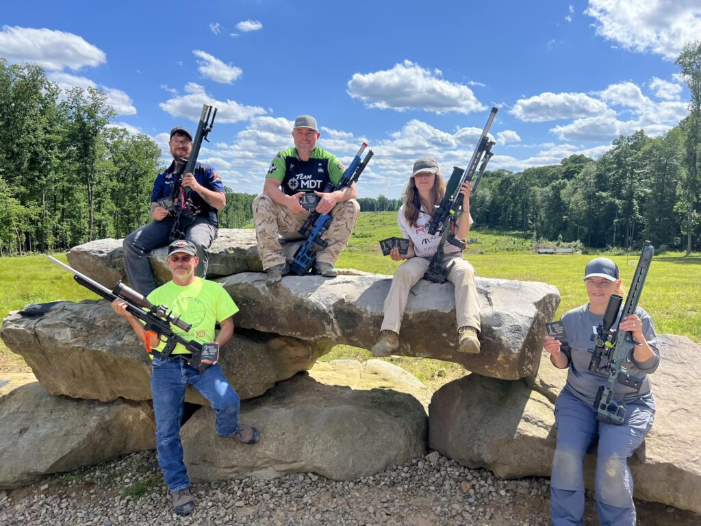 Rachel Precision shooters with their rifles on a rock at a match