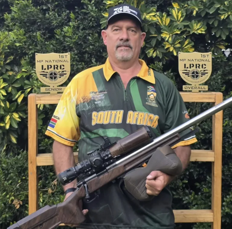 Glen Clark in his South Africa jersey with his rifle and his first-place Senior and Overall plaques from the MP National