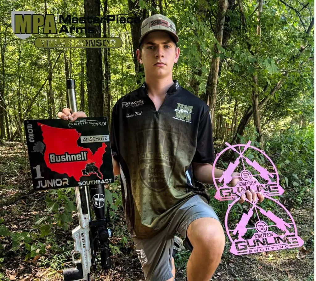 Hunter Neal in a Rachel Precision jersey with his rifle and his match plaques